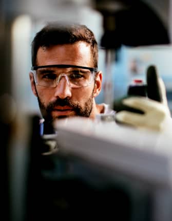 Engineer inspecting industrial equipment with safety glasses and gloves – THG Engineering Singapore